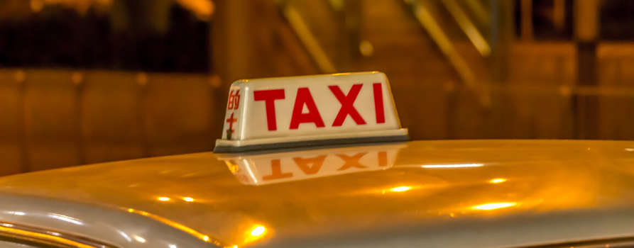 fragment żółtego dachu samochodu z tabliczką z napisem TAXI
