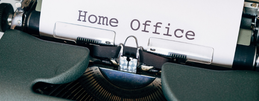 fragment maszyny do pisania, z której wystaje kartka z napisem home office