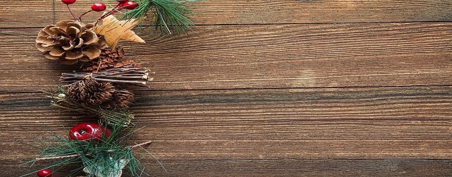 świąteczny stroik z gałązek i szyszek na drewnianej powierzchni