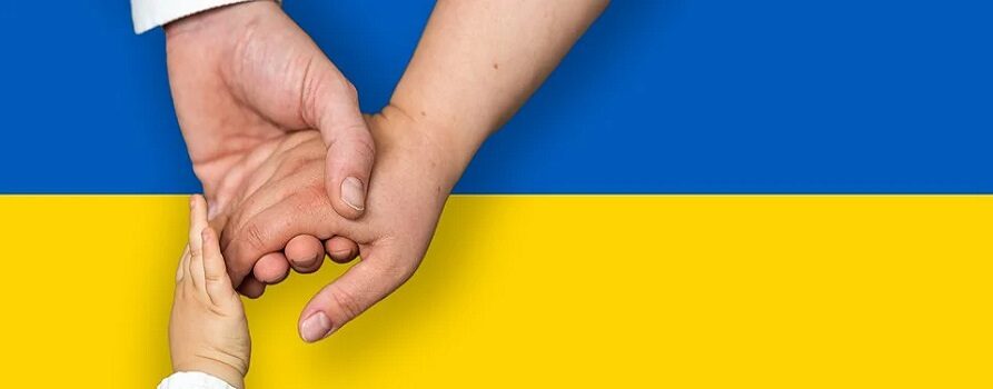 Trzy, trzymające się za siebie ręce na tle ukraińskiej flagi