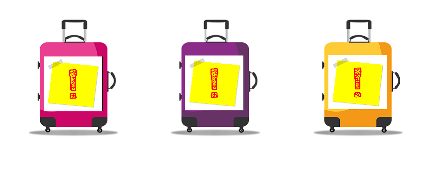 Trzy walizki na kółkach w kolorze różowym, fioletowym i żółtym, na każdej żółta karteczka typu post it z czerwonym wykrzynikiem w środku