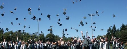 Zakończenie roku akademickiego, studenci rzucają w górę studenckie czapki