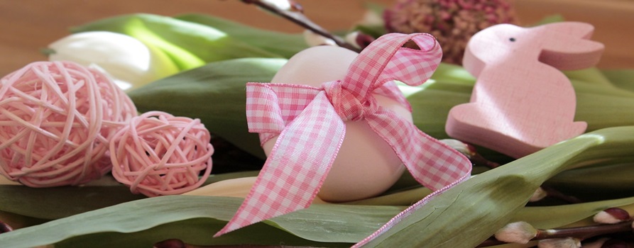 stroik świąteczny w kolorze różowym, składający się z jajek z włóczki, jajka, przewiązanego kokardą w kratkę i drewnianego króliczka